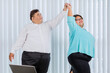 © Creativa Images - Happy fat business couple dancing in office
