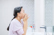 © Creativa Images - Senior woman doing treatment face skin in bathroom