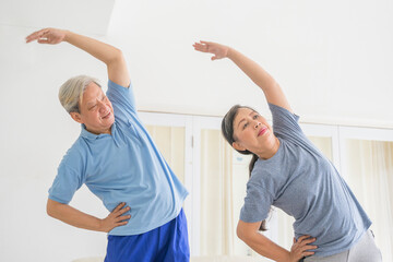 Wall Mural - Senior couple exercising together in living room