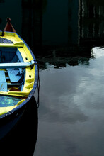 Blue And Yellow Wooden Row Boat On Water Reflecting The Sky - Colorful Old Row Boat With A Water Reflection