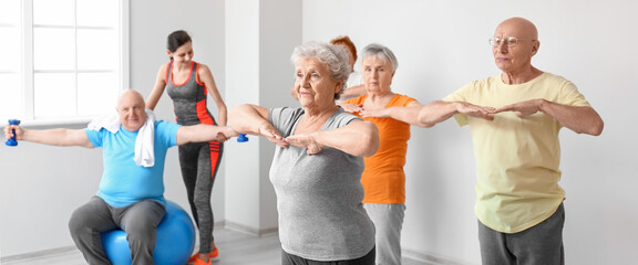 Wall Mural - Group of elderly people doing exercises in gym