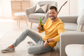 Wall Mural - Handsome man drinking beer at home