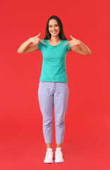 Wall Mural - Pretty young woman in stylish t-shirt on red background