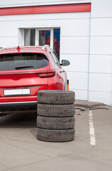 Poster - 4 new tires that change tires in the auto repair service center, blurred background, the background is a new car in the stock blur for the industry, a four-wheeled tire set at a large warehouse