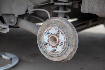 Poster - Disc brake of the vehicle for repair, in process of new tire replacement. Car brake repairing in garage.Suspension of car for maintenance brakes and shock absorber systems. Replacement of brake pads.