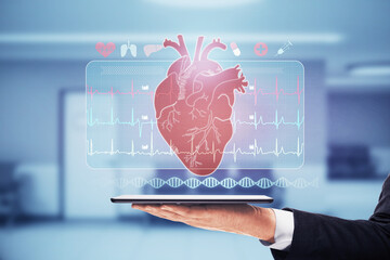 Wall Mural - Close up of businessman hand holding tablet with abstract glowing medical cardiology interface on blurry hospital background. Hi-tech technology and medicine of the future concept. Double exposure.