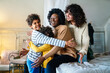 © NDABCREATIVITY - Happy lesbian multiethnic couple in love with childen at home. Family lgbt child happiness concept