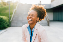 Afro Businesswoman Laughing In Front Of Staircase