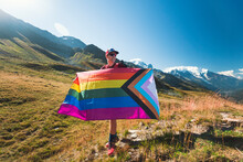 Man Holding LGBTIQ Community Flag In Mountains