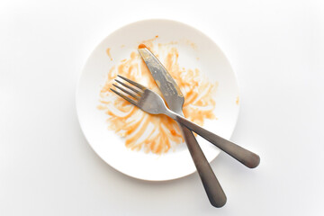 Dirty plate with knife and fork on the table. Photo can be used for the concept of how to clean the plate after food.