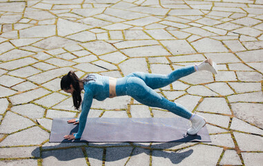 Wall Mural - Portrait of beautiful fit woman exercising in the park. Caucasian female fitness model working out in the morning.