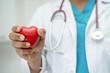 © amazing studio - Doctor holding a red heart in hospital ward, healthy strong medical concept.