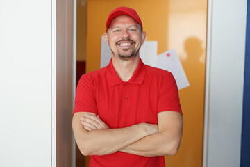 Happy man courier in red shirt and cap uniform, delivery worker