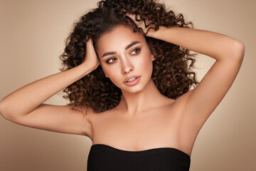 Fashion studio portrait of beautiful smiling woman with afro curls hairstyle. Fashion and beauty