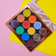 Colorful eyeshadow makeup palette. Realistic image with matte, glitter, multichrome pigments. Shadows set in vibrant colorful scheme. Top view flat lay package isolated on colorful background.