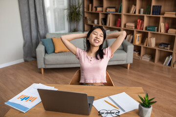 Poster - Relaxed young asian lady sitting with hands behind head near laptop, having break after online class or work at home