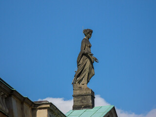 Wall Mural - Scenic view of an old statue depicting a woman in blue sky background in Berlin, Germany