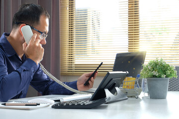 Poster - Businessman using smart phone and laptop at office. Businessman or student working on computer and texting smartphone. Freelance, education and technology concept