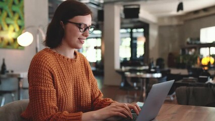Pensive red haired woman working in cafe
