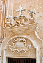 Part Of The Gate, Richly Decorated With Ornaments, Figures And A Cross. Photo From Mdina, Malta