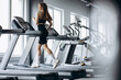 © Petro - Sporty woman running on treadmill at the gym