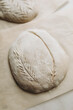 bread dough sprinkled with flour on top. baking craft bread. cut out patterns on bread dough. craft bread close-up. 
