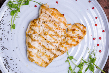 Poster - Fried chicken breast on grey plate on dark stone table top view