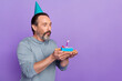 Profile side photo of mature man blow candle dreamy delicious dessert isolated over violet color background