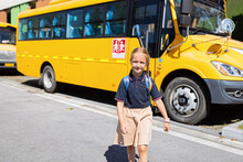 Back To School. Little Girl From Elementary School Outdoor Near Yellow Bus. Kid Going Learn New Things 1th September