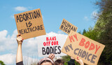 Fototapeta Mapy - Protesters holding signs Abortion Is Healthcare, My Body My Choice, Bans Off Our Bodies, Human rights. People with placards supporting abortion rights at protest rally demonstration.