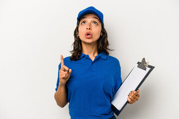 Wall Mural - Young hispanic woman delivery man isolated on white background pointing upside with opened mouth.