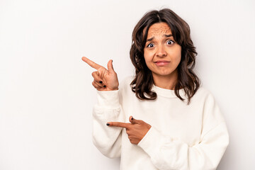 Wall Mural - Young hispanic woman isolated on white background shocked pointing with index fingers to a copy space.