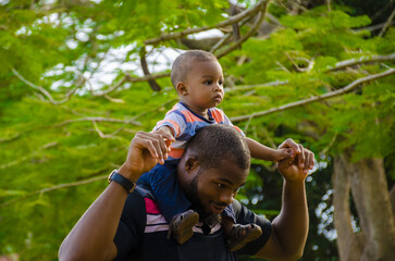 Sticker - Cute African baby with her father relaxing in a park