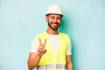 Wall Mural - Young laborer hispanic man isolated on blue background showing number two with fingers.