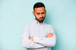 © Asier - Young hispanic man isolated on blue background frowning face in displeasure, keeps arms folded.