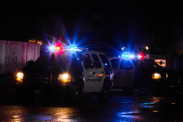 Wall Mural - Police cruisers vehicles with flashing lights at vehicle accident on cold wet dark night