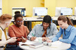 © Seventyfour - Vibrant shot of diverse group of young people studying together at table in college lab