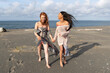 African American woman and redhead woman together on ocean beach