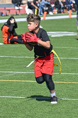 Wall Mural - Young athletic boy catching, running and throwing the ball in a football game