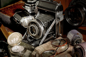 Wall Mural - An old camera in a composition on an old background, on a table