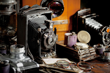 Wall Mural - An old camera in a composition on an old background, on a table