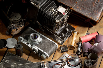 Wall Mural - An old camera in a composition on an old background, on a table