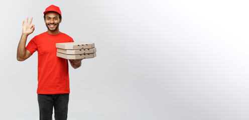 Poster - Delivery Concept - Portrait of Handsome African American Pizza delivery man making ok sign with fingers. Isolated on Grey studio Background. Copy Space.