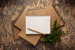 Notebook and branch with leaf on chipboard plywood background texture. Recycling concept