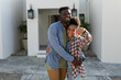 © Wavebreak Media - Portrait of cheerful african american young man embracing young girlfriend holding new house key