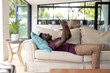 © Wavebreak Media - African american young man surfing net over digital tablet while relaxing on sofa in living room