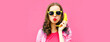 Colorful portrait of funny young woman calling on banana phone on pink background