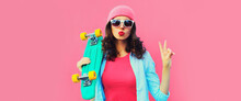 Summer Colorful Portrait Of Stylish Modern Young Woman Model Posing With Green Skateboard And Blowing Her Lips Wearing Hat On Pink Background