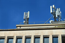 Telecommunications Antennas Placed On The Roof Of A Building Against A Blue Sky On A Sunny Day
