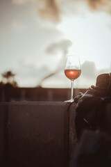 Poster - Vertical shot of a wine glass on the balcony against the sunrise in Vilanova, Barcelona, Spain